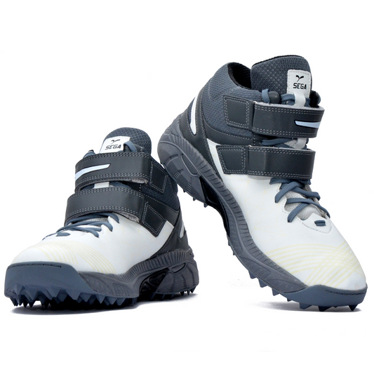 A pair of white, and grey cricket bowling shoes with rubber studs and an external strap for support.