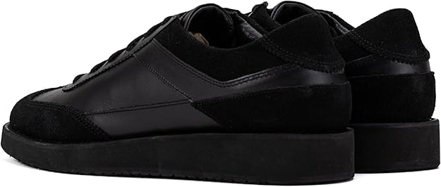 A pair of black suede leather semi-formal trainers with a lace-up closure and a thick sole.