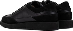 A pair of black suede leather semi-formal trainers with a lace-up closure and a thick sole.