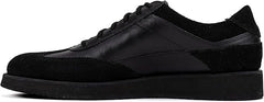 A pair of black suede leather semi-formal trainers with a lace-up closure and a thick sole.