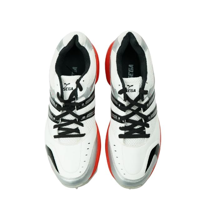 A pair of white cricket shoes with red accents and a distinctive design on the sole.