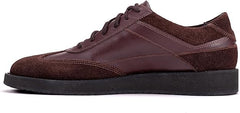 A pair of brown suede leather semi-formal trainers with a lace-up closure and a thick sole.