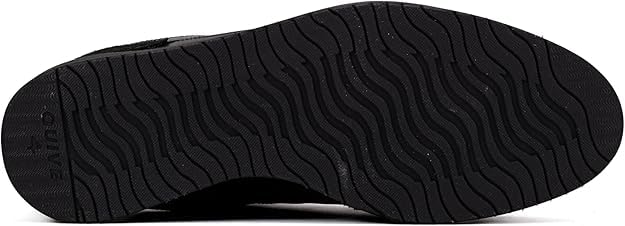 A pair of black suede leather semi-formal trainers with a lace-up closure and a thick sole.