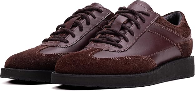 A pair of brown suede leather semi-formal trainers with a lace-up closure and a thick sole.