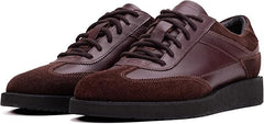 A pair of brown suede leather semi-formal trainers with a lace-up closure and a thick sole.