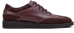 A pair of brown suede leather semi-formal trainers with a lace-up closure and a thick sole.