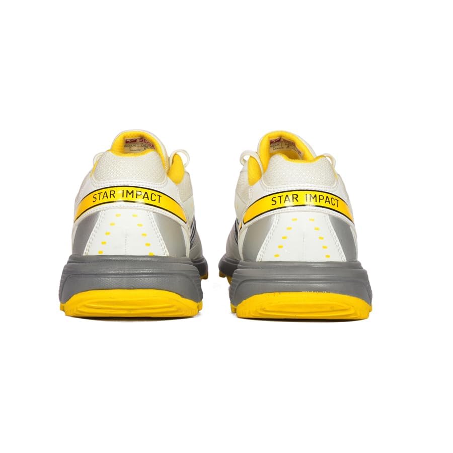 A pair of white cricket shoes with yellow accents and a distinctive design on the sole.