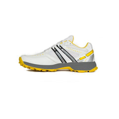 A pair of white cricket shoes with yellow accents and a distinctive design on the sole.