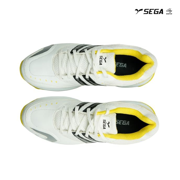A pair of white cricket shoes with yellow accents and a distinctive design on the sole.