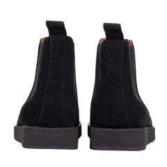 A pair of black leather Chelsea boots with a rubber sole.