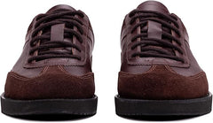 A pair of brown suede leather semi-formal trainers with a lace-up closure and a thick sole.