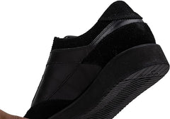 A pair of black suede leather semi-formal trainers with a lace-up closure and a thick sole.