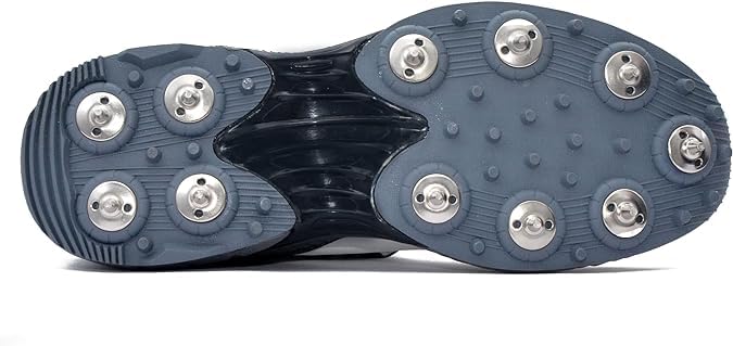 A pair of white, and grey cricket bowling shoes with metal spikes and an external strap for support.