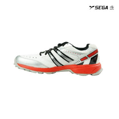 A pair of white cricket shoes with red accents and a distinctive design on the sole.