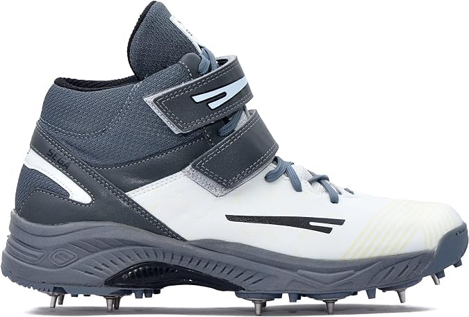 A pair of white, and grey cricket bowling shoes with metal spikes and an external strap for support.