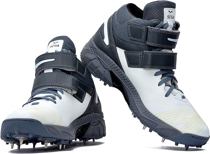 A pair of white, and grey cricket bowling shoes with metal spikes and an external strap for support.
