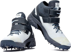 A pair of white, and grey cricket bowling shoes with metal spikes and an external strap for support.
