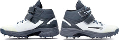 A pair of white, and grey cricket bowling shoes with metal spikes and an external strap for support.