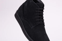 Pair of black suede high-top boots on a white background