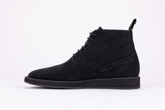 Pair of black suede high-top boots on a white background