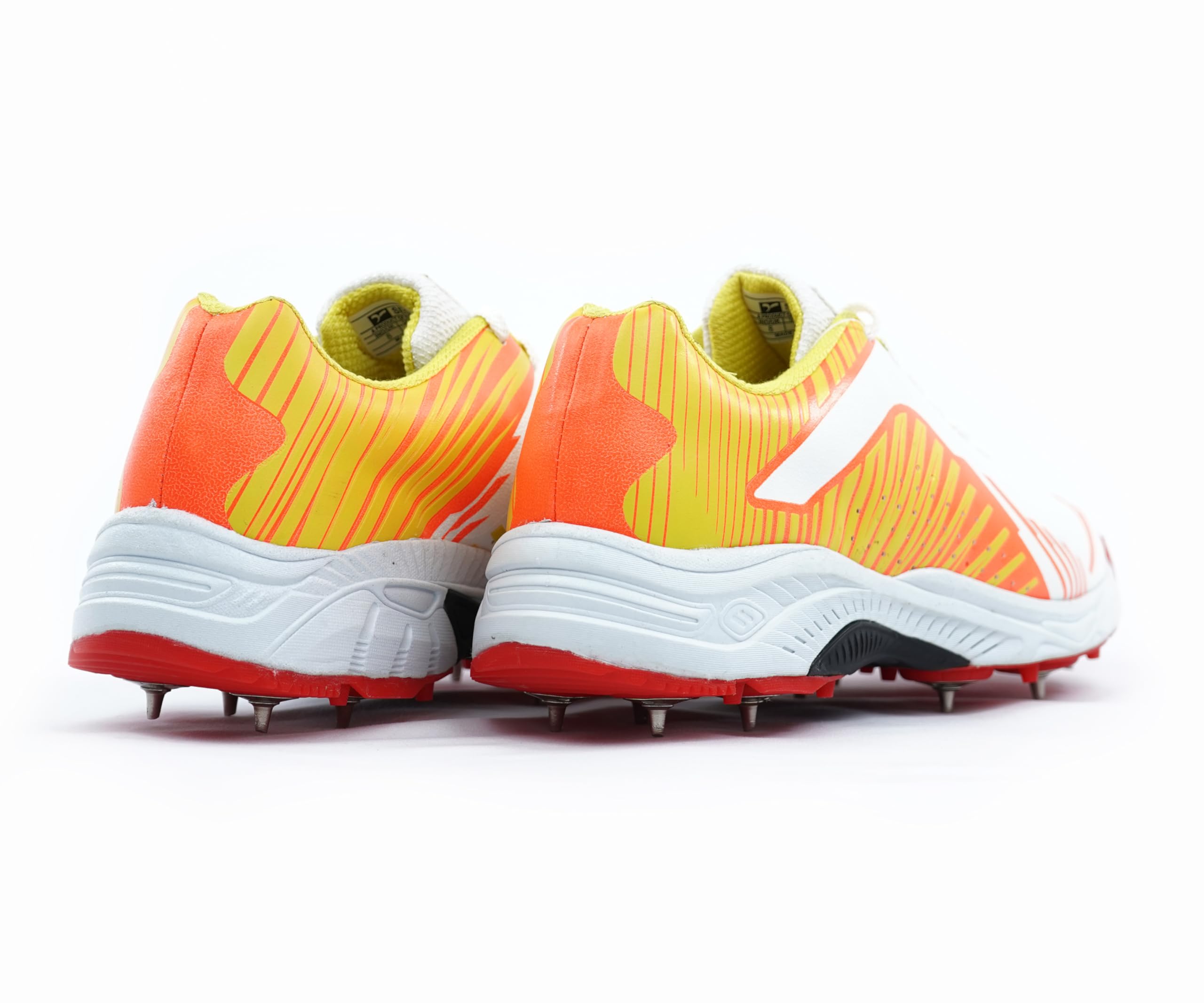 White, orange, and red cricket shoes sports cleats on a white background