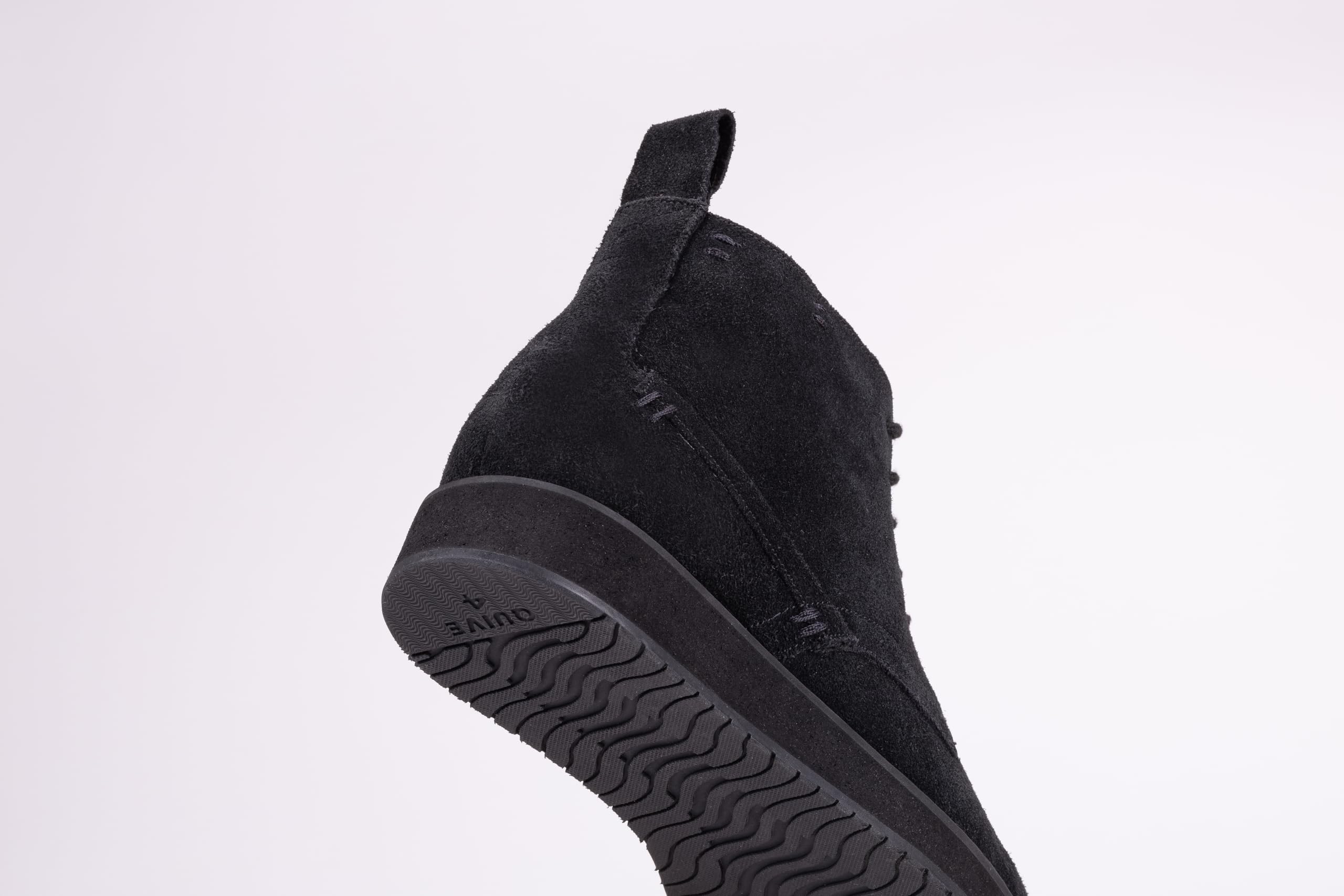Pair of black suede high-top boots on a white background