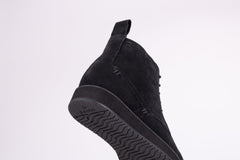 Pair of black suede high-top boots on a white background