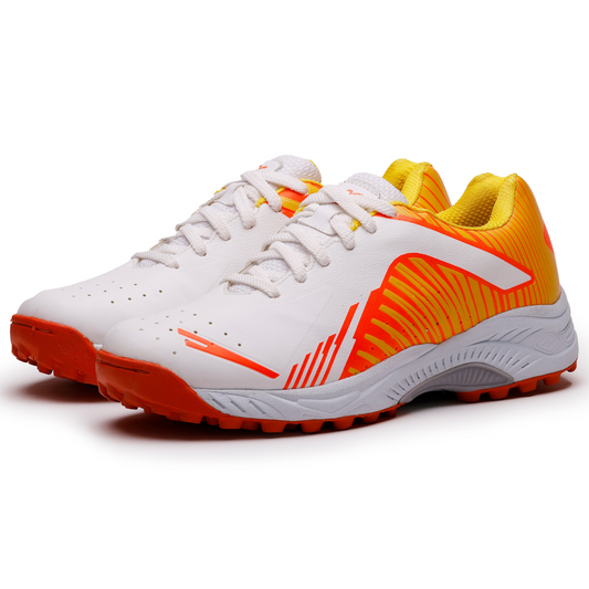 A pair of white, and orange cricket shoes with rubber studs and an lace up for support.