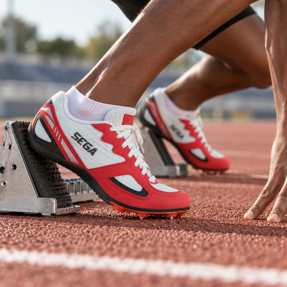 Red and white SEGA Endurance track spikes worn in starting blocks