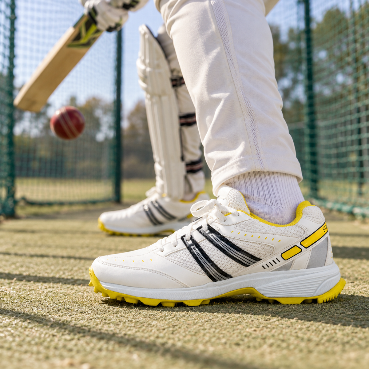 White and yellow SEGA Glide cricket training shoes worn during batting warm-up
