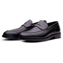 A pair of men's black leather penny loafers with a low stacked heel, shown from a three-quarters angle on a white background.
