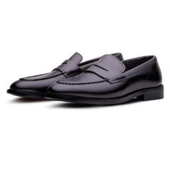 Pair of black loafers on a white background
