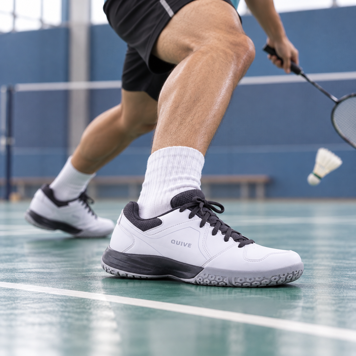 White QUIVE Hyper court shoes worn during an indoor badminton drill